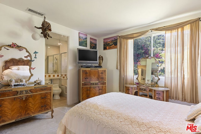 carpeted bedroom featuring ensuite bath