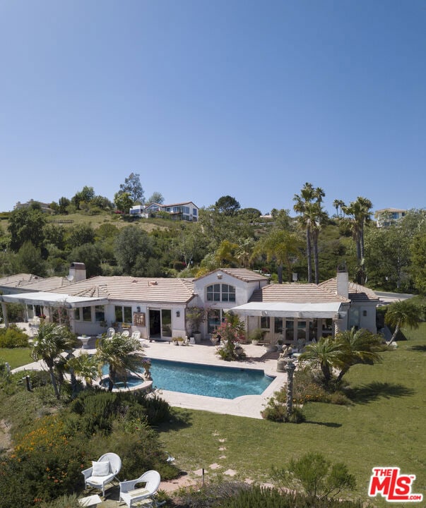 view of swimming pool featuring a patio and a yard