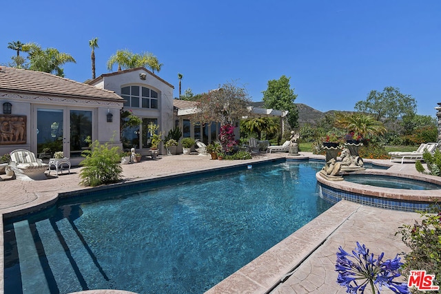 view of pool with a patio and an in ground hot tub