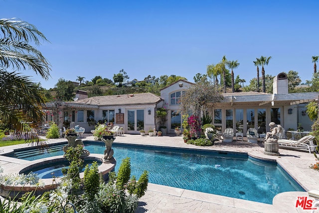 view of swimming pool featuring an in ground hot tub and a patio area