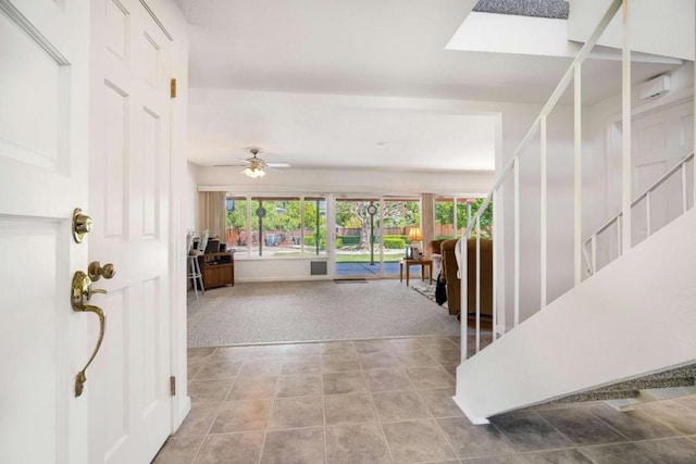 interior space with a skylight, a wealth of natural light, ceiling fan, and carpet floors