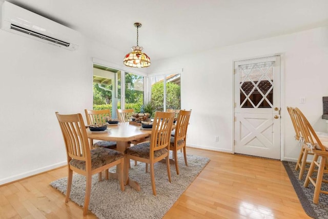 dining room with light wood-type flooring and a wall unit AC