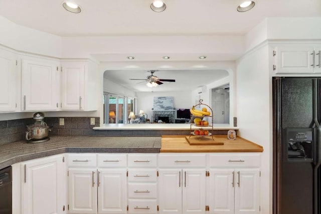 kitchen with ceiling fan, black appliances, kitchen peninsula, and white cabinetry