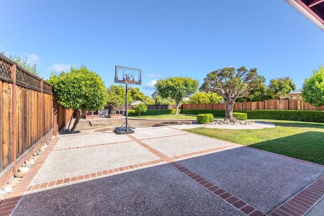 view of sport court with a lawn