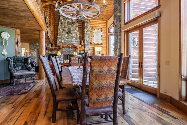 dining space with high vaulted ceiling, dark wood-type flooring, a notable chandelier, and french doors