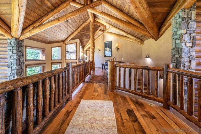 corridor with vaulted ceiling with beams, wooden ceiling, and dark wood-type flooring