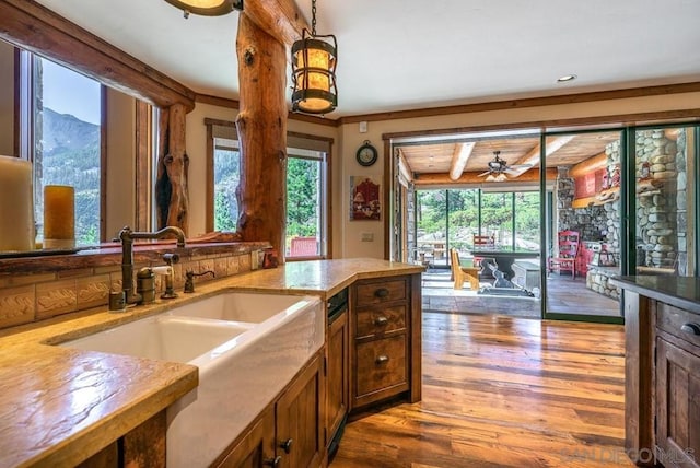 kitchen with dark hardwood / wood-style floors, ceiling fan, sink, a mountain view, and beam ceiling