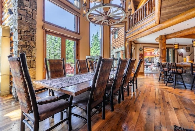 dining room with hardwood / wood-style flooring, a chandelier, and a towering ceiling