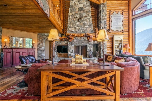 interior space featuring high vaulted ceiling, log walls, a stone fireplace, and dark wood-type flooring