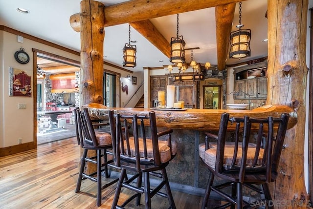 bar with beamed ceiling, stainless steel fridge, pendant lighting, and light wood-type flooring