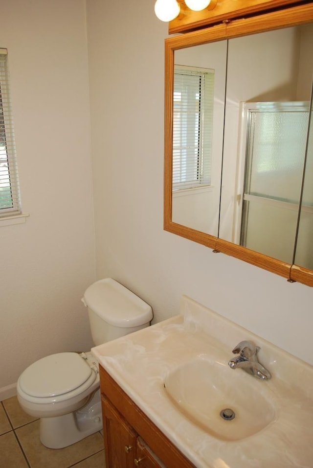 bathroom featuring toilet, vanity, and tile flooring