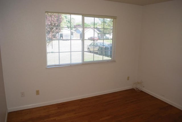 unfurnished room with a wealth of natural light and dark hardwood / wood-style flooring