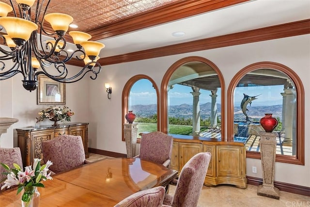 dining room with an inviting chandelier, a mountain view, light tile floors, and ornamental molding