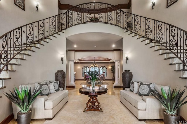 living room featuring an inviting chandelier, decorative columns, and a high ceiling