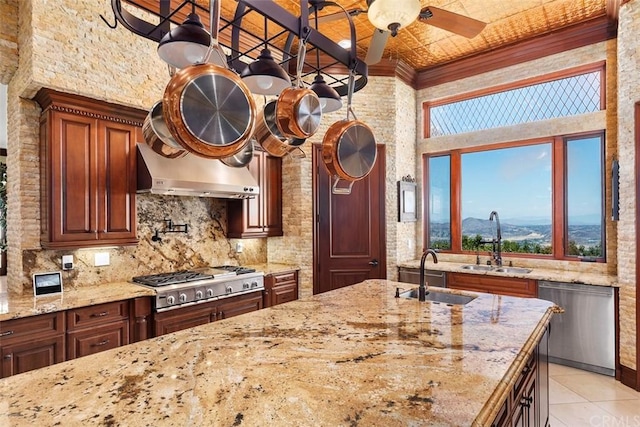 kitchen with ceiling fan, a mountain view, stainless steel appliances, a towering ceiling, and tasteful backsplash