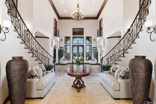 living room with a chandelier, a towering ceiling, and ornamental molding