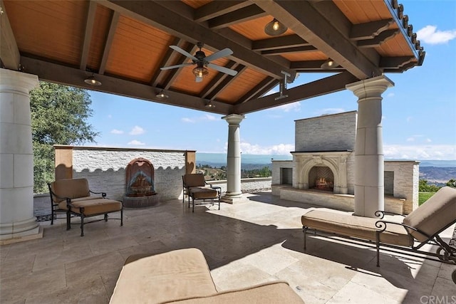 view of patio / terrace with a gazebo, exterior fireplace, and ceiling fan