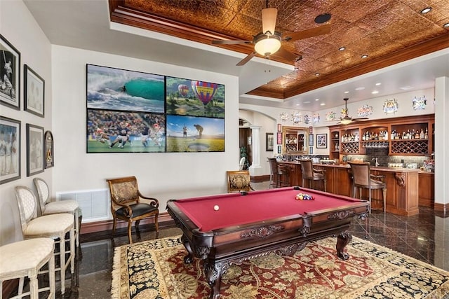 rec room with dark tile floors, ceiling fan, bar area, billiards, and a tray ceiling