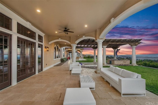 patio terrace at dusk featuring ceiling fan, a pergola, an outdoor hangout area, and french doors