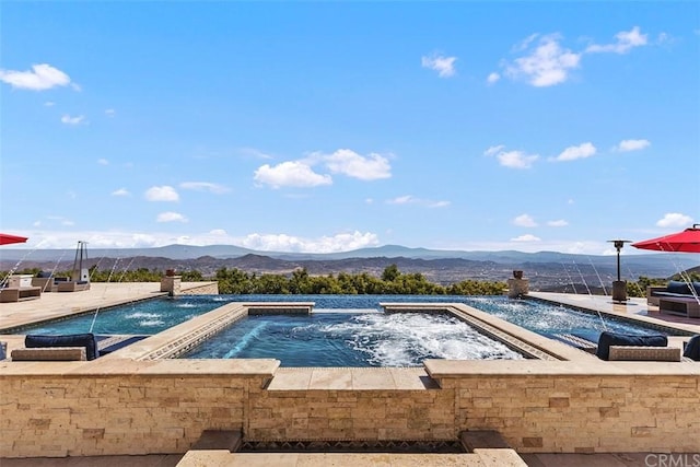 view of pool with a mountain view and an in ground hot tub