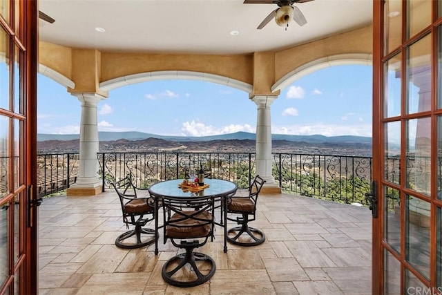 view of terrace featuring a balcony, a mountain view, and ceiling fan