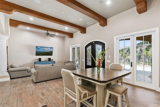 dining room featuring french doors, beamed ceiling, light wood-type flooring, and ceiling fan