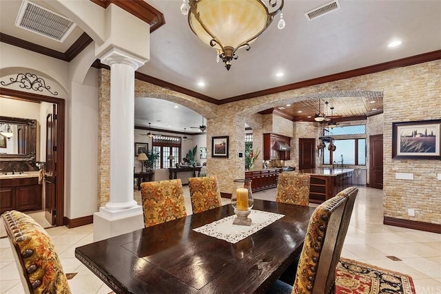 tiled dining area with crown molding, ceiling fan, and ornate columns