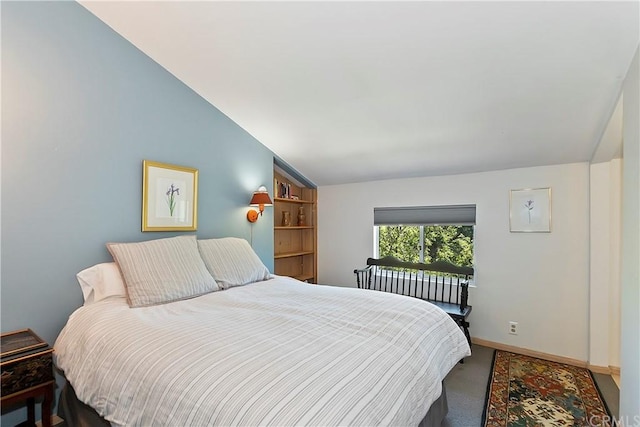 bedroom featuring carpet and vaulted ceiling