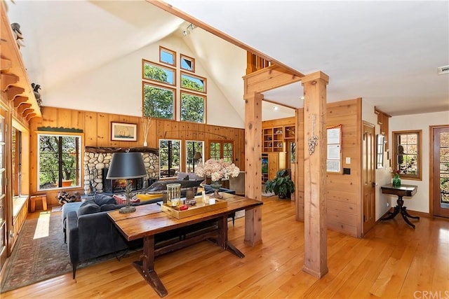 living room with light hardwood / wood-style floors, a wealth of natural light, and a high ceiling