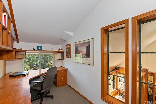 carpeted office featuring vaulted ceiling