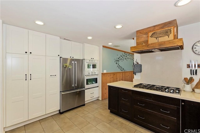 kitchen with stainless steel appliances, white cabinets, and custom exhaust hood