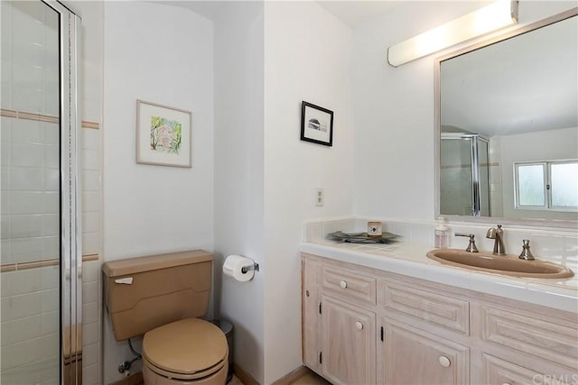 bathroom with toilet, a shower with door, and vanity