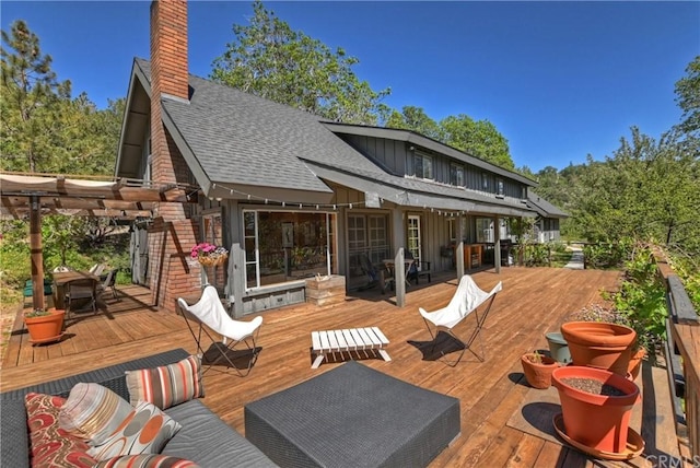 rear view of property featuring a wooden deck and outdoor lounge area