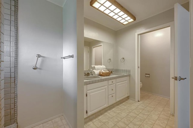 bathroom featuring dual vanity, toilet, and tile patterned floors