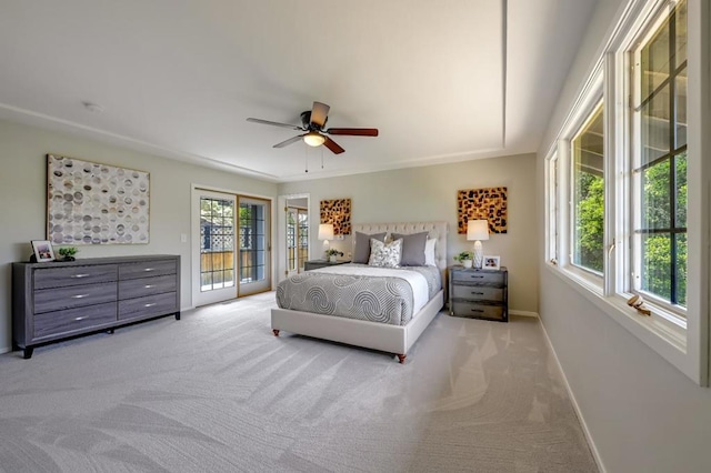 bedroom featuring ceiling fan, light carpet, and multiple windows