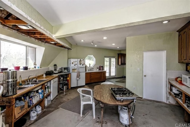 kitchen with french doors, white appliances, sink, and concrete flooring