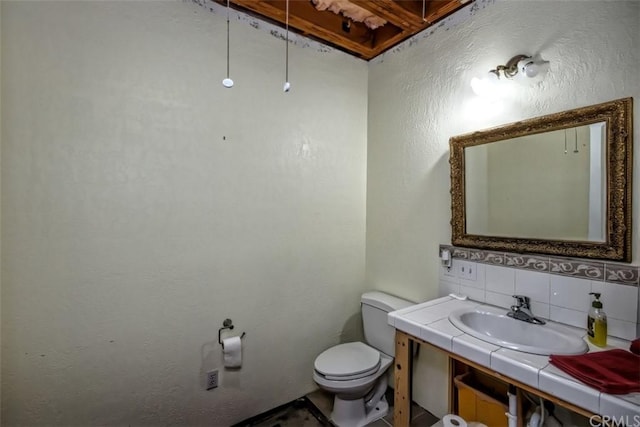 bathroom featuring tasteful backsplash, toilet, and vanity