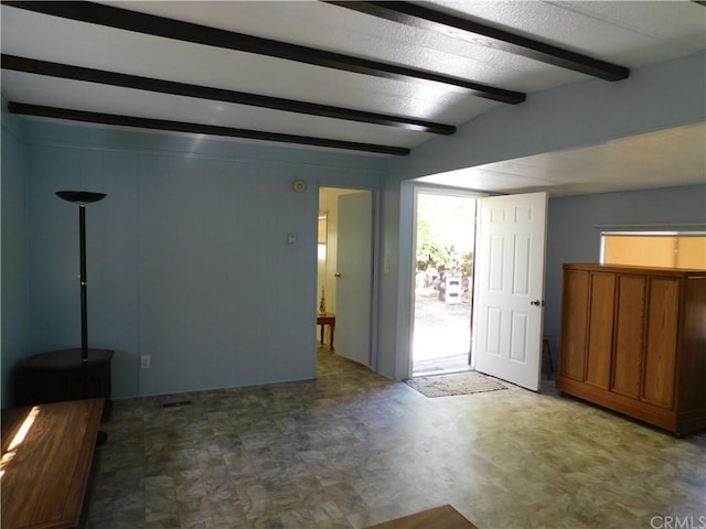 empty room featuring beamed ceiling