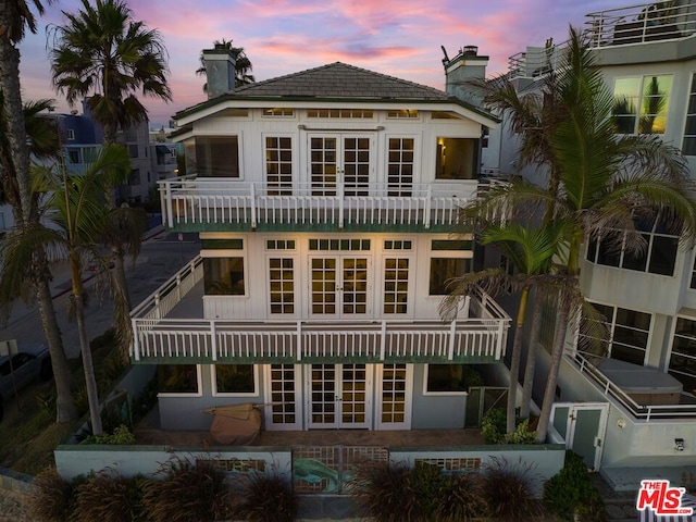 back house at dusk featuring french doors