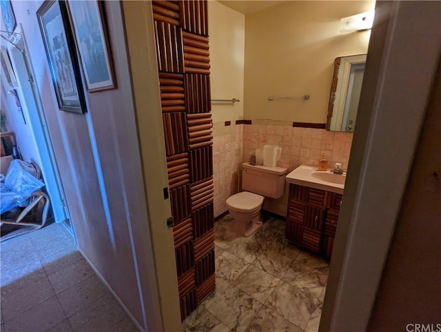 bathroom with tile floors, vanity, toilet, and tasteful backsplash