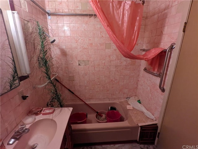 bathroom with shower / bath combination with curtain, tile walls, and sink