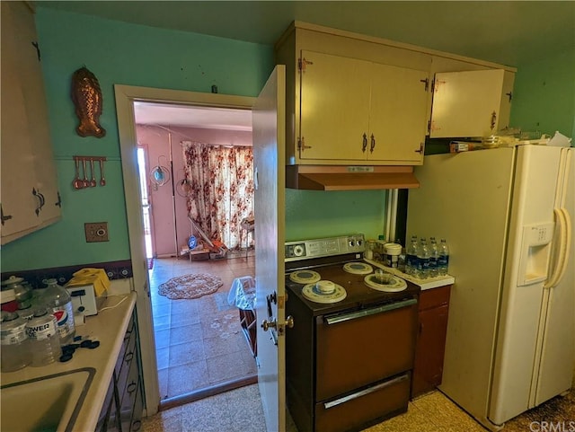 kitchen featuring white fridge with ice dispenser, sink, range with electric cooktop, and light tile floors