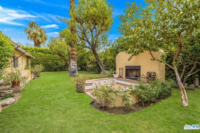 view of yard with exterior fireplace