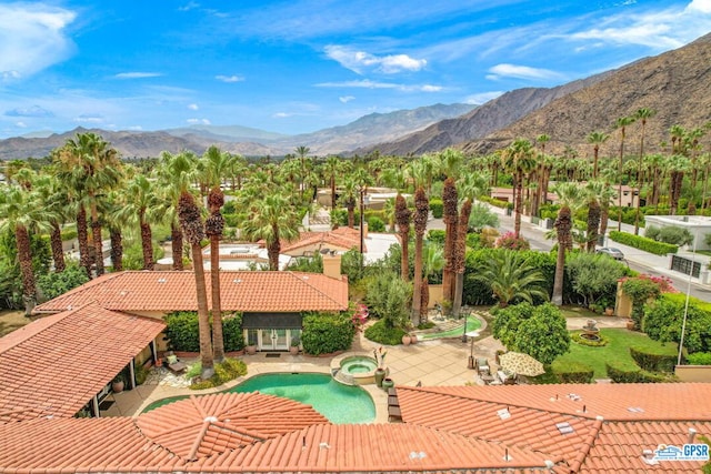 view of pool featuring a mountain view, an in ground hot tub, and a patio area