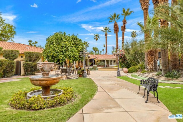 view of home's community with a lawn and a patio