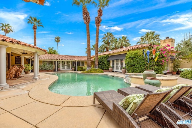 view of swimming pool featuring a patio area and an in ground hot tub