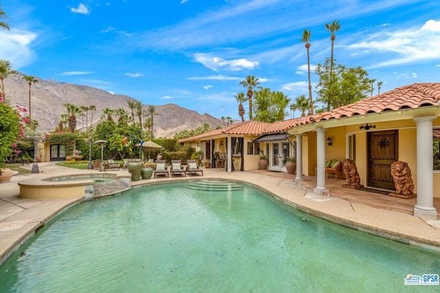 view of swimming pool featuring a mountain view, ceiling fan, a patio area, and an in ground hot tub