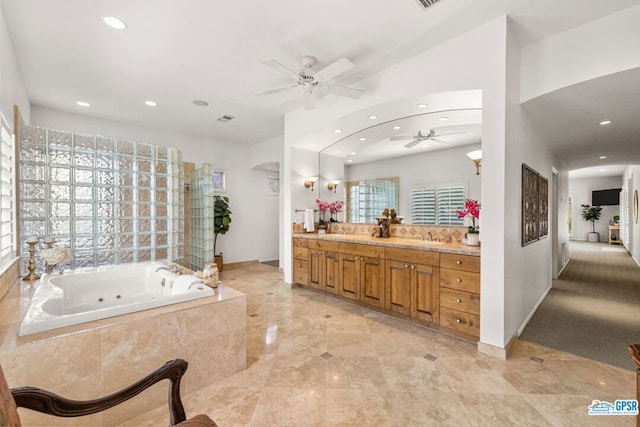 bathroom with vanity and a relaxing tiled tub