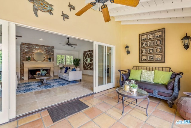 interior space featuring ceiling fan, french doors, wooden ceiling, vaulted ceiling with beams, and a fireplace