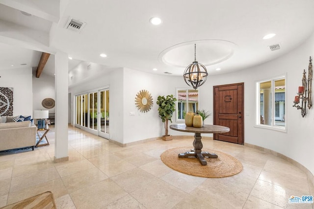 entrance foyer with beam ceiling and a notable chandelier